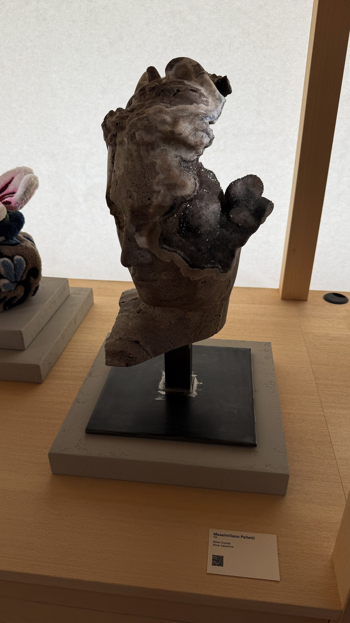 A sculpted face meeting a crystalline surface.