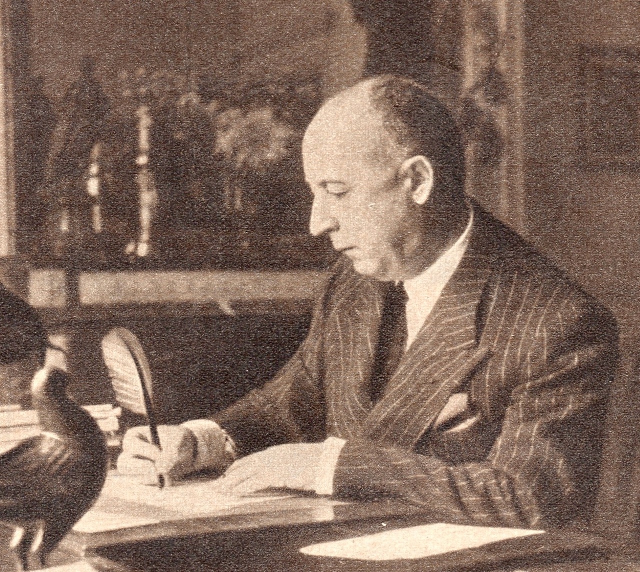 Christian Dior writing at his desk in 1954.