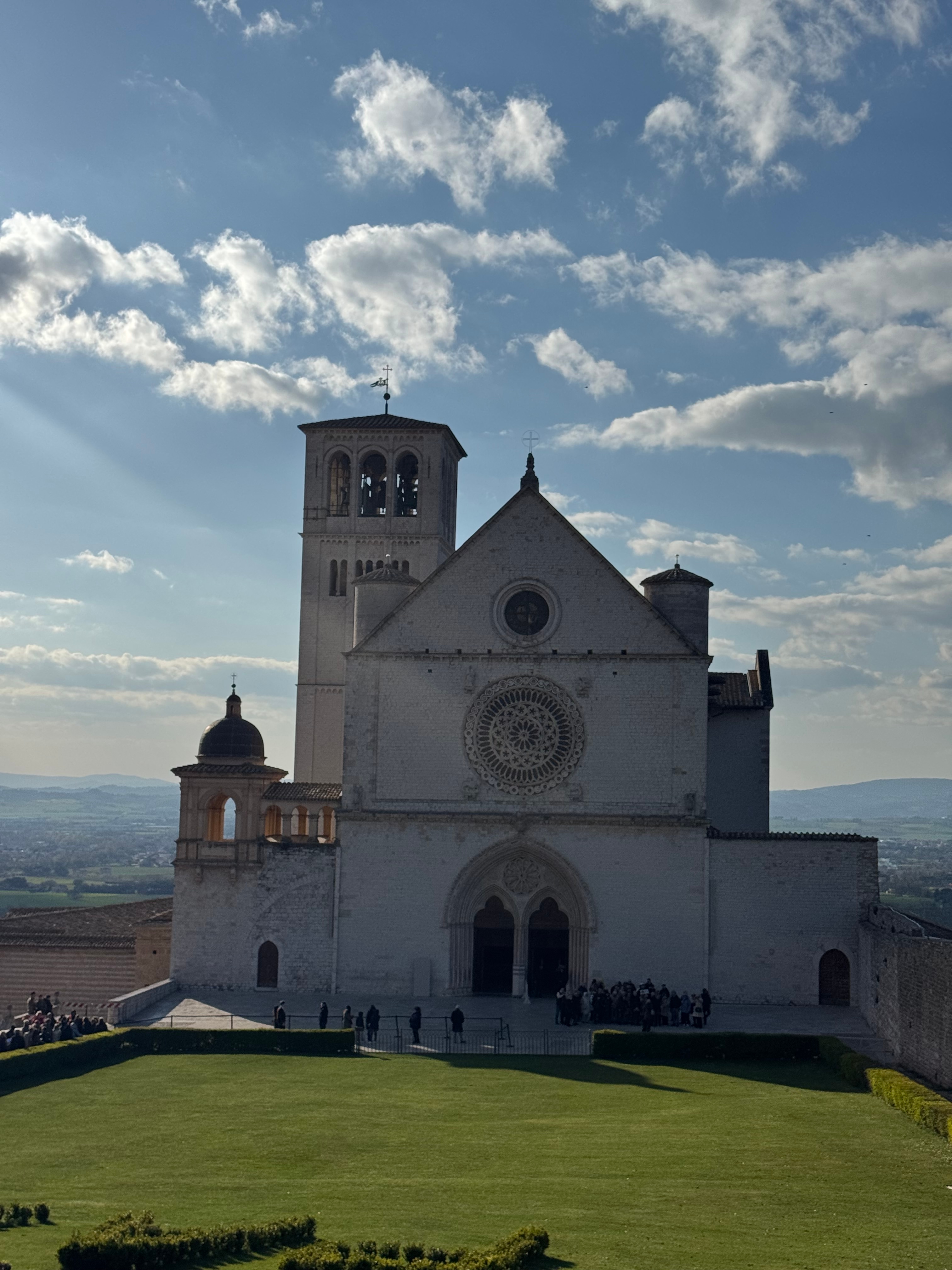 The Basilica of Saint Francis in Assisi beneath a pale sky.