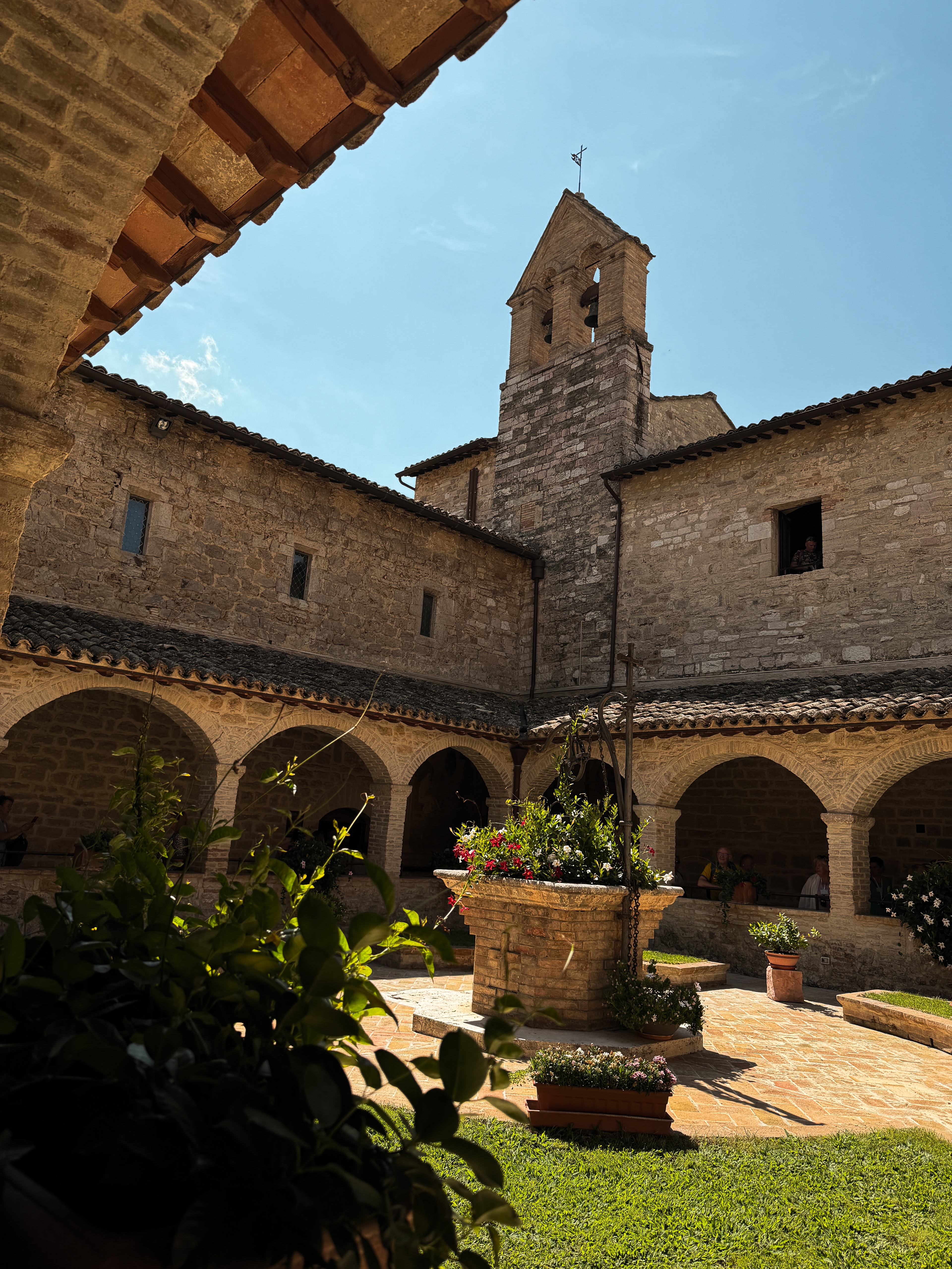 A stone courtyard and bell tower at San Damiano in Assisi.