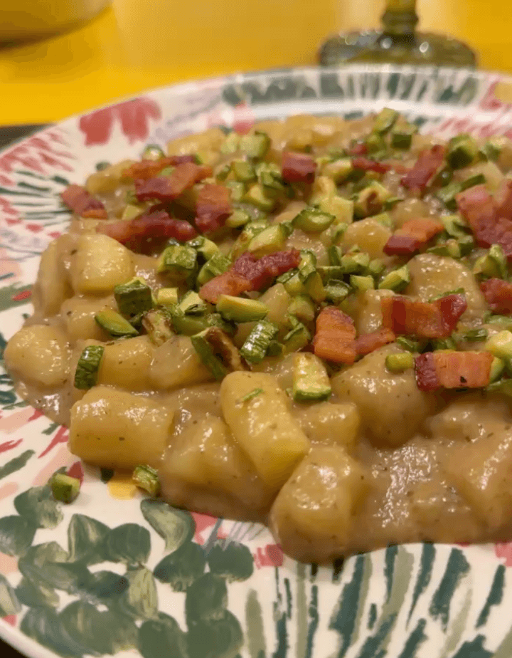 Gnocchi with diced zucchini on a patterned plate.